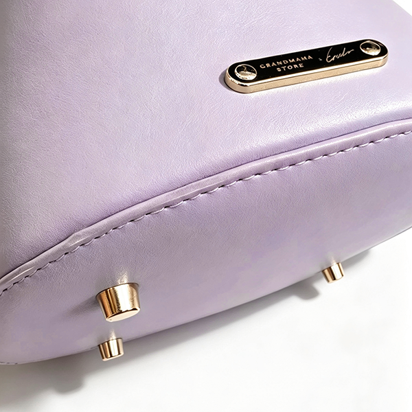 Base feet and logo plaque on lavender Mt. Fuji Goen Bag at Grandmama Store in Hong Kong