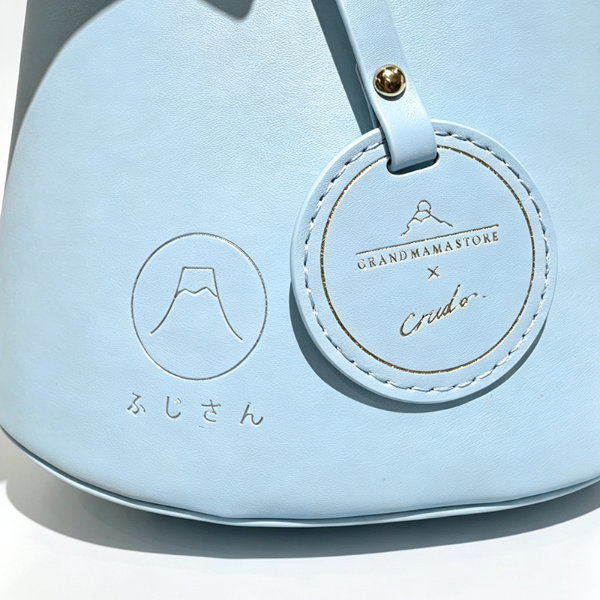 Close-up of debossed logo and charm on Mt. Fuji Goen Bag in Light Blue at Grandmama Store in Hong Kong