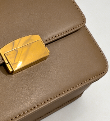 Close-up of gold push-lock hardware on taupe Square Side Bag at Grandmama Store in Hong Kong