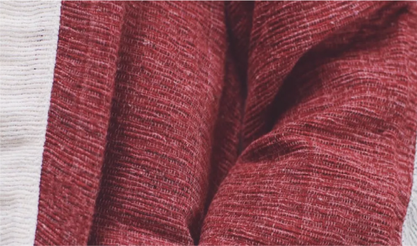 Extreme close-up of the textured, slub-knit fabric on the Tokyo Tower red Hand-cranked Kimono at Grandmama Store in Hong Kong.