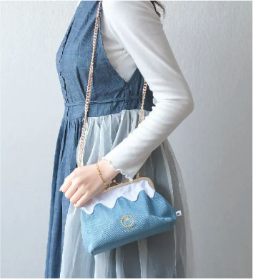 Model wearing the Light Blue denim Mt. Fuji Pocket Bag with gold chain strap at Grandmama Store in Hong Kong.