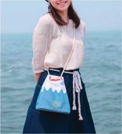 Model wearing the Mt. Fuji Sake Bag in Light Blue cross-body at Grandmama Store in Hong Kong