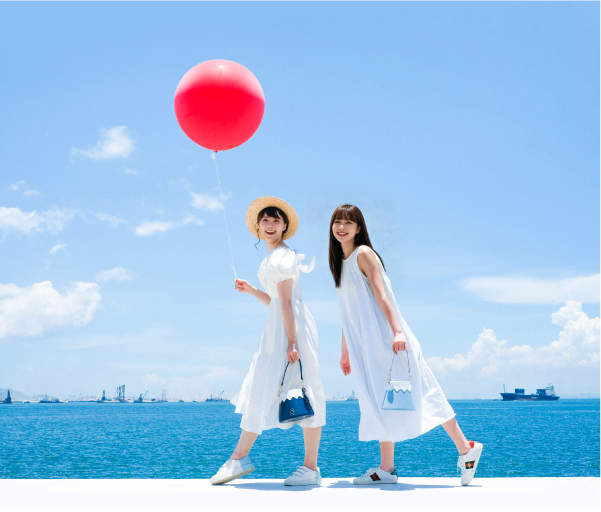 Two models styling the Mt. Fuji Goen Bag in Navy and Light Blue outdoors at Grandmama Store in Hong Kong