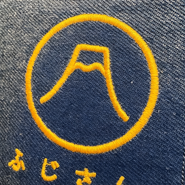 Yellow embroidery thread on dark blue canvas detail at Grandmama Store in Hong Kong