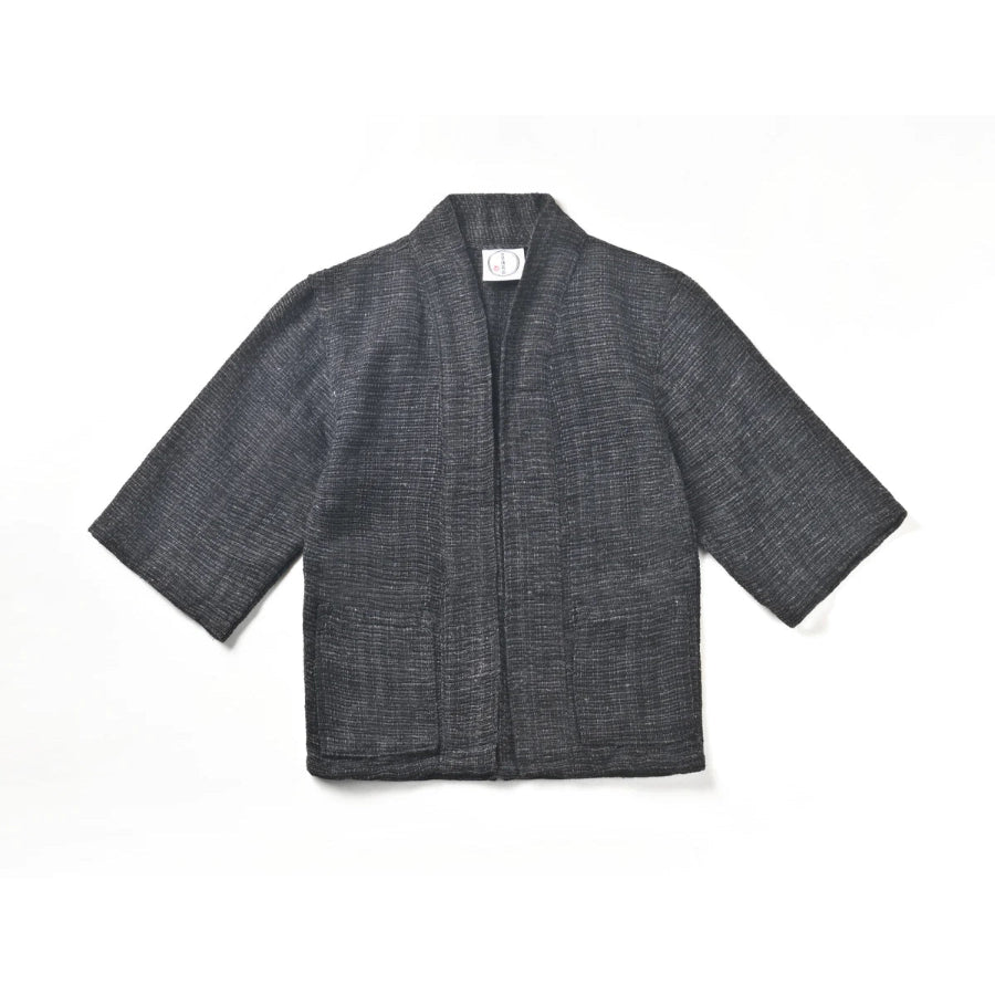 A flat lay image of a hand-cranked Kimono jacket in Miho Matsubara color featuring textured charcoal gray handwoven cotton fabric at Grandmama Store in Hong Kong.