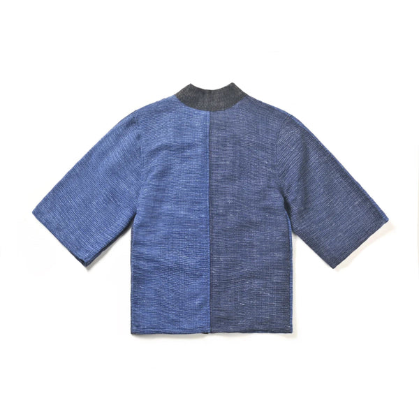 The back view of a panel-design hand-cranked Kimono jacket in Moonlight color showing the textured medium blue and dark blue split fabric at Grandmama Store in Hong Kong.