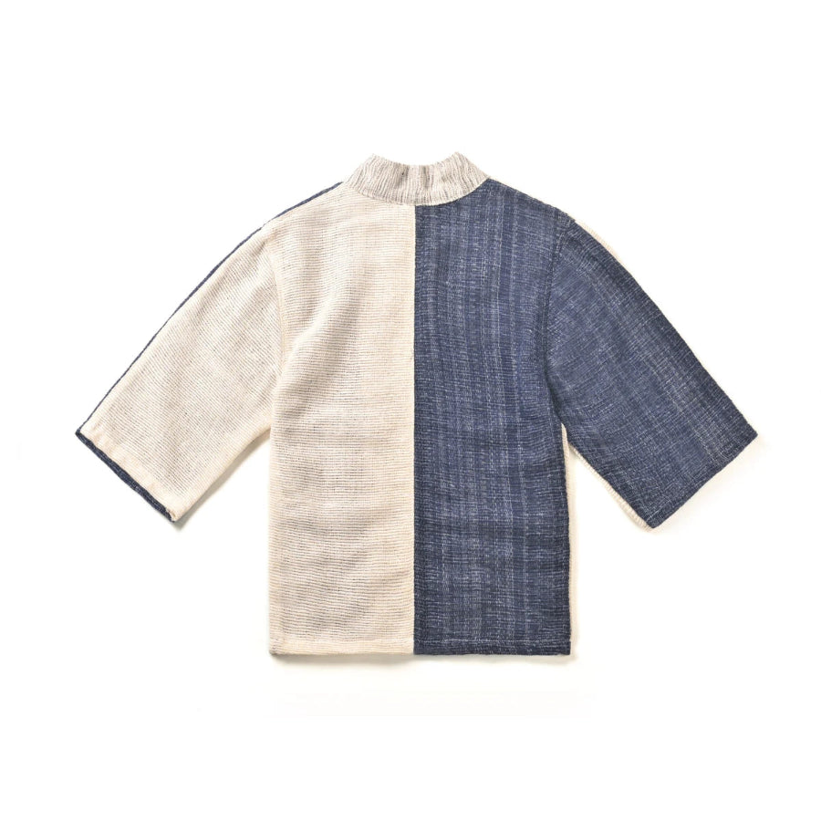 The back view of a panel-design hand-cranked Kimono jacket in Mt. Fuji color showing the textured cream-beige and indigo blue split fabric at Grandmama Store in Hong Kong.