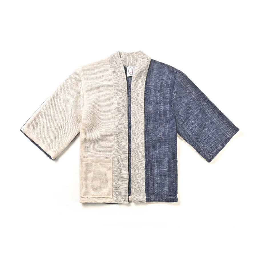 A flat lay image of a panel-design hand-cranked Kimono jacket in Mt. Fuji color featuring textured cream, indigo blue, and gray handwoven cotton fabrics at Grandmama Store in Hong Kong.