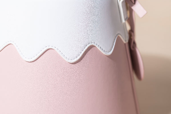 A close-up view showcasing the intricate split-panel design of the Mt. Fuji Goen Bag, featuring a wavy white top panel meticulously stitched onto a dusty pink base. The photograph highlights the heavily textured leather surface, which mimics a fine slub-knit texture with a subtle shimmery finish under the light at Grandmama Store in Hong Kong.